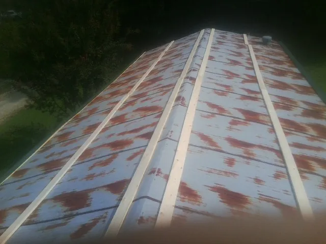 Rusted metal roof panels with new wood purlins before replacement — Storm Damage Roof Repair in Pheba by Roofing Brothers